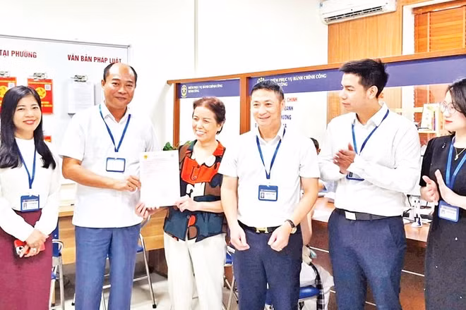 Lãnh đạo phường Định Công trao sổ đỏ cho người dân.