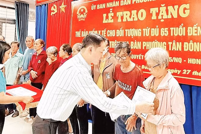 Trao thẻ Bảo hiểm y tế cho người cao tuổi phường Tân Đông Hiệp. (Ảnh: VÕ LÊ)