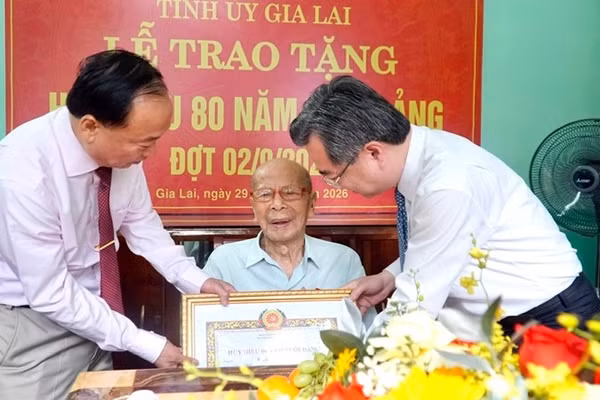 Đồng chí Nguyễn Thanh Nghị, Ủy viên Bộ Chính trị, Bí thư Trung ương Đảng, Trưởng ban Chính sách, Chiến lược Trung ương (bên phải) và đồng chí Thái Đại Ngọc, Bí thư Tỉnh ủy Gia Lai trao Huy hiệu 80 năm tuổi Đảng cho đồng chí Phan Ngọc Bích. (Ảnh: SỸ THẮNG)