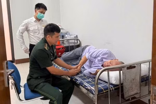 Bộ đội Biên phòng Quảng Ninh và phối hợp với kiểm dịch y tế quốc tế sơ cứu kịp thời nam hành khách người Trung Quốc. (Ảnh: Quang Thọ)