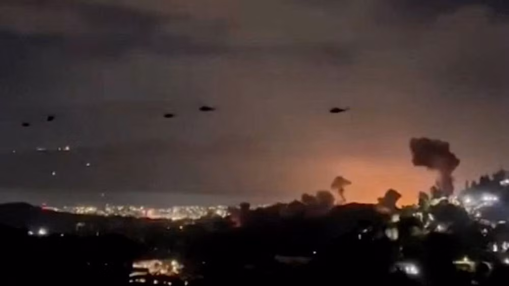 Trực thăng bay qua khu vực khói bốc lên từ loạt vụ nổ ở thủ đô Caracas, Venezuela, ngày 3/1/2026. (Ảnh: TTXVN)