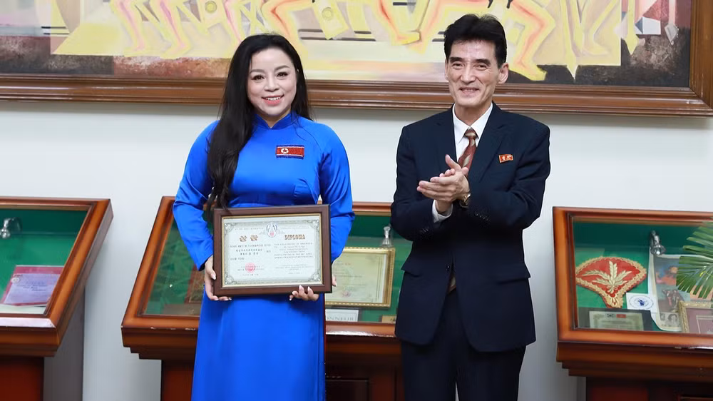 Đại sứ Ri Sung Guk trao cúp và bằng khen cho Nghệ sĩ Ưu tú Tố Nga. (Ảnh: Nhân vật cung cấp)