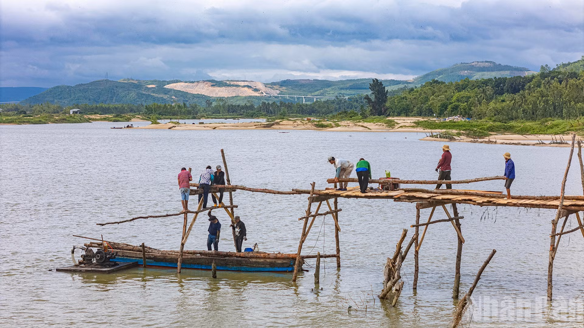 Người dân xây dựng lại cầu gỗ Ông Cọp sau khi công trình bị lũ cuốn đi vào tháng 11 vừa qua.