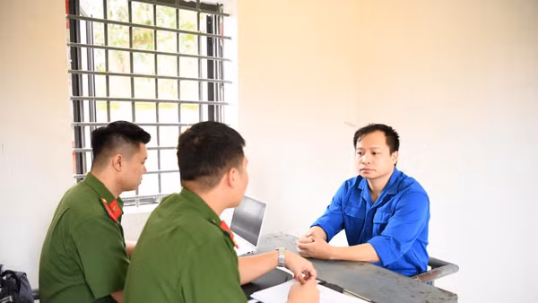 Điều tra viên lấy lời khai bị can Lê Đức Hùng. (Ảnh do Công an cung cấp)