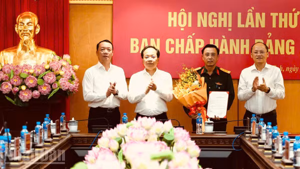 Các đồng chí Thường trực Tỉnh ủy Hà Tĩnh trao quyết định, tặng hoa chúc mừng Đại tá Phạm Văn Sâm (Ảnh: NGÔ TUẤN)