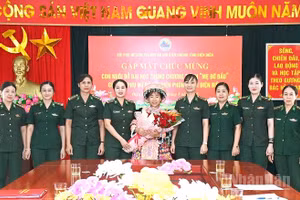 Các mẹ đỡ đầu ở Ban Chỉ huy Bộ đội Biên phòng tỉnh Điện Biên tặng hoa, chúc mừng cháu Sùng Thị Khoa. (Ảnh: LÊ LAN)