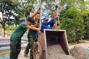 Đoàn viên, thanh niên Trường trung học phổ thông Thanh Nưa cùng các chiến sĩ thực hiện nhiệm vụ khai quật, lấy mẫu hài cốt liệt sĩ. (Ảnh: LÊ LAN)