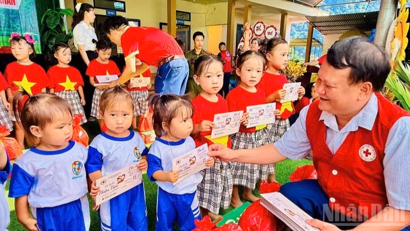 Lãnh đạo Hội Chữ thập đỏ tỉnh Điện Biên trao quà tặng các cháu học sinh mầm non tại điểm Trường mầm non Ca Hâu. (Ảnh: LÊ LAN)