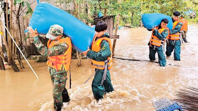 Cán bộ, chiến sĩ Bộ Chỉ huy Quân sự tỉnh Đắk Lắk giúp nhân dân xã Ea Súp di dời tài sản đến nơi an toàn. (Ảnh CÔNG LÝ)