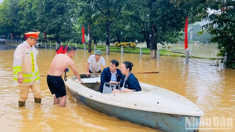 Cảnh sát giao thông tỉnh Lào Cai dùng thuyền nan hỗ trợ đại biểu kịp thời gian dự Đại hội Đảng bộ tỉnh. (Ảnh: THANH SƠN).