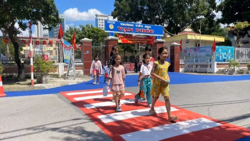 Học sinh Trường tiểu học Vạn Phúc (Hà Nội) tự tin đi trên đoạn đường dành riêng cho người đi bộ khu vực trước cổng trường.