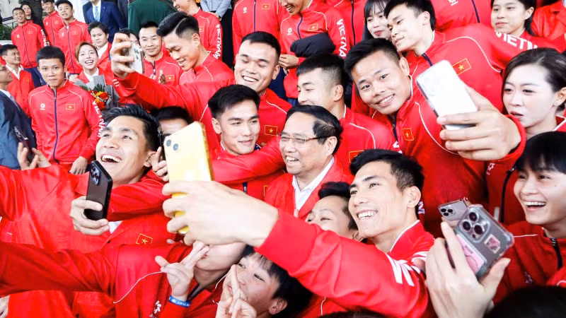 Thủ tướng Phạm Minh Chính trong trang phục thi đấu của Đoàn Thể thao Việt Nam tham dự SEA Games 33 chụp hình lưu niệm với các vận động viên.