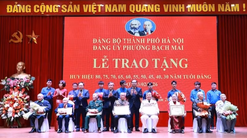 Đồng chí Chủ tịch Ủy ban nhân dân thành phố Hà Nội Vũ Đại Thắng và các đồng chí lãnh đạo phường Bạch Mai trao huy hiệu 80 năm, 75 năm, 70 năm tuổi Đảng tặng các đảng viên. (Ảnh: Đình Hiệp)
