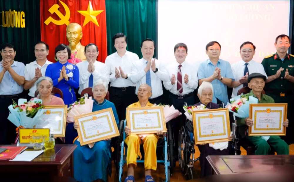 Bí thư Tỉnh ủy Nghệ An Nguyễn Đức Trung và các đại biểu chụp ảnh lưu niệm cùng 5 đảng viên lão thành cách mạng được trao Huy hiệu Đảng. (Ảnh: BP)