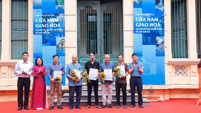 Bí thư Đảng ủy phường Cửa Nam Phạm Tuấn Long tặng hoa các tác giả có tác phẩm trưng bày tại triển lãm “Cửa Nam giao hòa - Cửa ngõ văn hóa, kết nối di sản, đổi mới sáng tạo”.