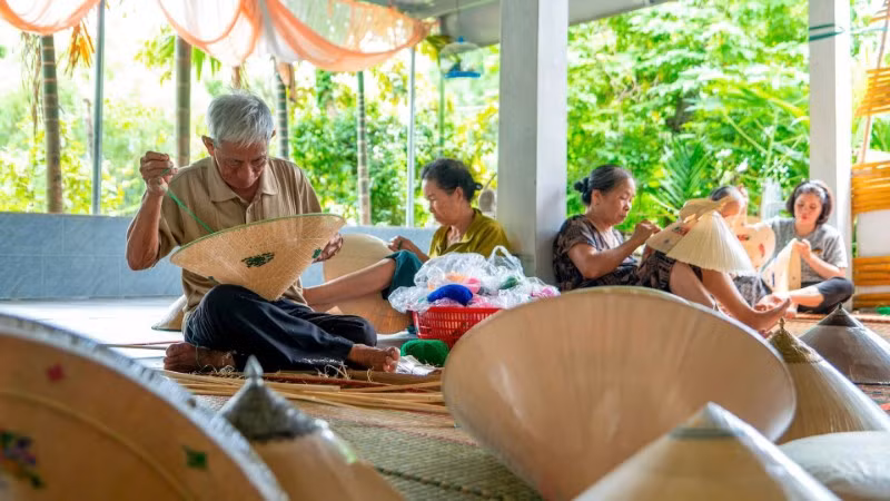Nghệ nhân Ưu tú Đỗ Văn Lan đang thêu các họa tiết cho chiếc nón ngựa. (Ảnh: MỸ HÀ)