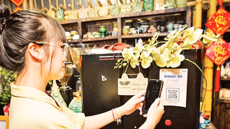 Khách hàng quét mã thanh toán không sử dụng tiền mặt tại cửa hàng trên phố Văn Miếu (Thành phố Hà Nội). (Ảnh: BẢO LONG)