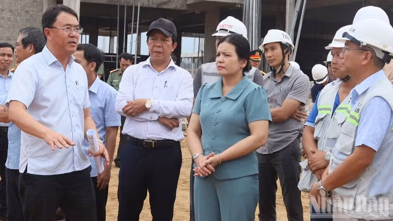 Giám đốc Ban Quản lý dự án đầu tư Tây Quảng Ngãi Võ Đại Tân (đứng bên trái) báo cáo tiến độ triển khai xây dựng trường nội trú liên cấp vùng biên.