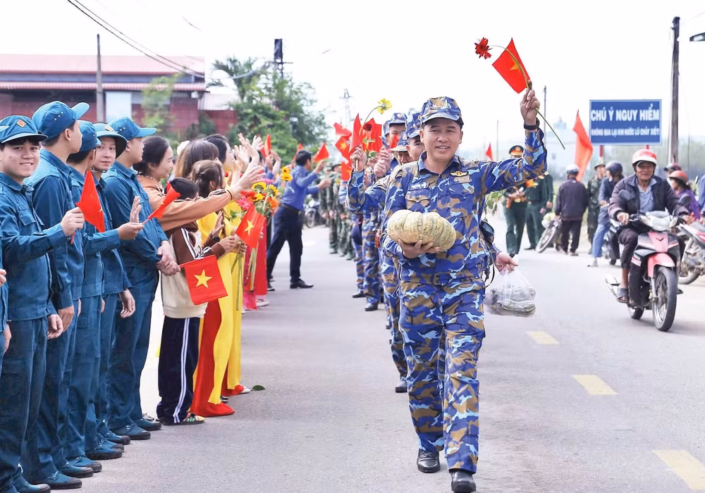 Người dân đứng bên đường lưu luyến chia tay bộ đội sau khi hoàn thành xuất sắc “Chiến dịch Quang Trung”. (Ảnh PHÚC THẮNG)