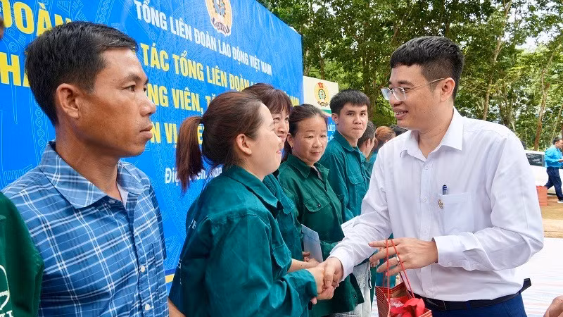 Đồng chí Nguyễn Ngọc Cẩm (áo trắng) Tổng Giám đốc Công ty Cổ phần Cao-su Điện Biên trao quà động viên công nhân, người lao động làm việc trực tiếp tại các vườn cây.