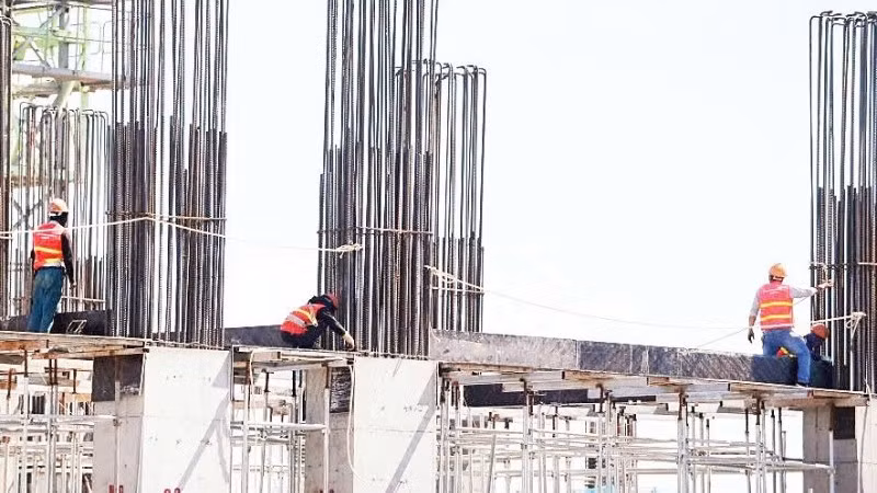 Công nhân làm việc dưới thời tiết khắc nghiệt trên công trường xây dựng. (Ảnh: QUÁCH DU)