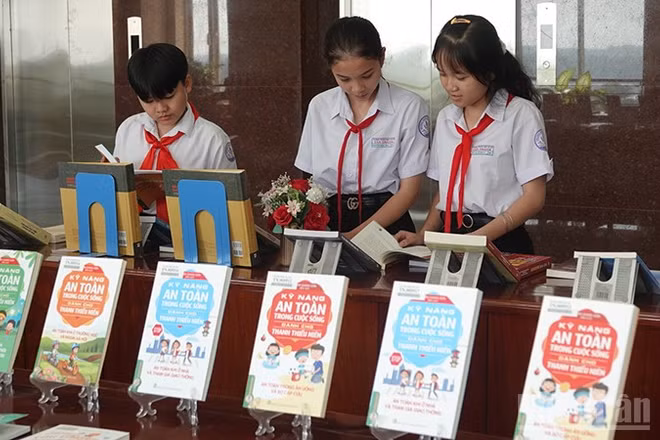 Các bạn nhỏ đang xem sách được trưng bày tại chương trình. (Ảnh: BẢO LINH)