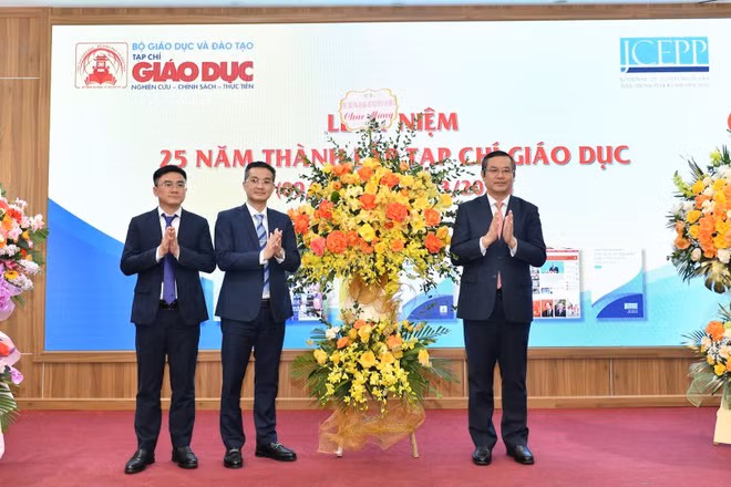 Thứ trưởng Bộ Giáo dục và Đào tạo Nguyễn Văn Phúc (bên phải ảnh) chúc mừng, tặng hoa lãnh đạo Tạp chí Giáo dục. 