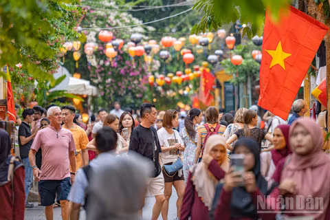 Lá Quốc kỳ tung bay trên những tuyến phố đông nghẹt người khiến không gian phố cổ Hội An trong những ngày này thêm phần trang trọng.