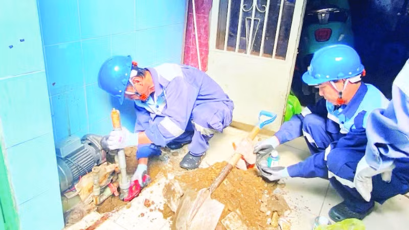 Công nhân Công ty cổ phần cấp nước Gia Định trám, lấp một giếng khoan tại phường Phú Nhuận nhằm hạn chế những tác động tiêu cực do hiện tượng mạch nước ngầm sụt giảm. (Ảnh QUÝ HIỀN)