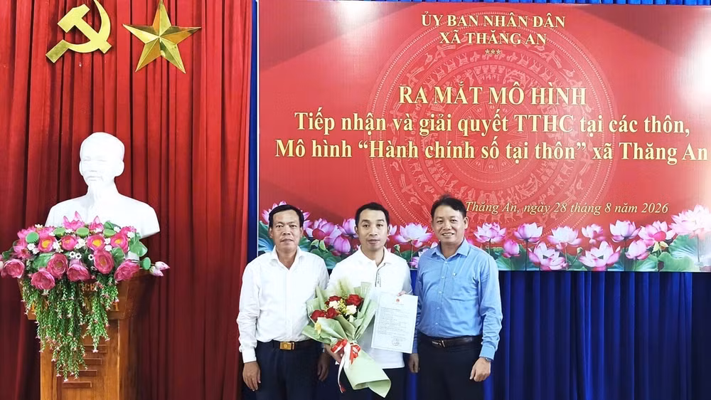 Lãnh đạo xã Thăng An trao kết quả và tặng hoa chúc mừng công dân khi thực hiện thủ tục hành chính tại buổi ra mắt mô hình. 