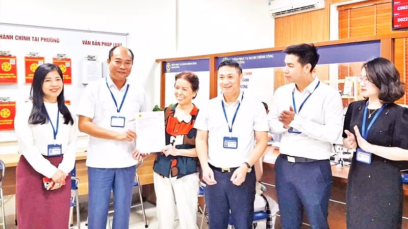 Lãnh đạo phường Định Công trao sổ đỏ cho người dân.