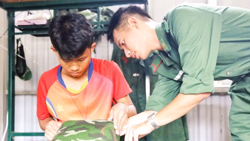 Hồ Lanh được chiến sĩ biên phòng hướng dẫn gấp chăn, gối trước khi về nội trú ở trường học mới.