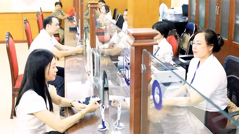Giải quyết thủ tục hành chính cho người dân tại điểm phục vụ hành chính công phường Thanh Xuân. (Ảnh QUANG THÁI)