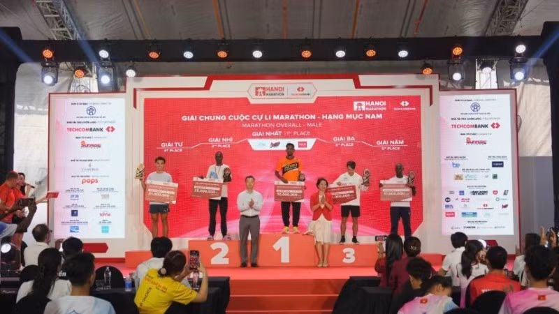 Bà Lê Thị Hoàng Yến, Phó Cục trưởng Cục TDTT và ông Phạm Xuân Tài, Phó Giám đốc Sở Văn hóa và Thể thao Thành phố Hà Nội trao giải cho các VĐV xuất sắc đường đua marathon nam.