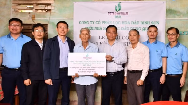Đại diện Công ty cổ phần Lọc hóa dầu Bình Sơn trao số tiền 60 triệu đồng hỗ trợ gia đình ông Huỳnh Kiễn sửa nhà.