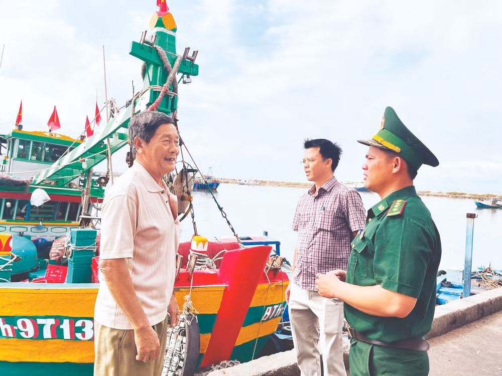 Chiến sĩ Đồn Biên phòng Thanh Hải (Lâm Đồng) cùng với cán bộ Ủy ban nhân dân phường Phú Thủy tuyên truyền ngư dân về trước ngày bỏ phiếu bầu cử. (Ảnh: THANH HẢI)