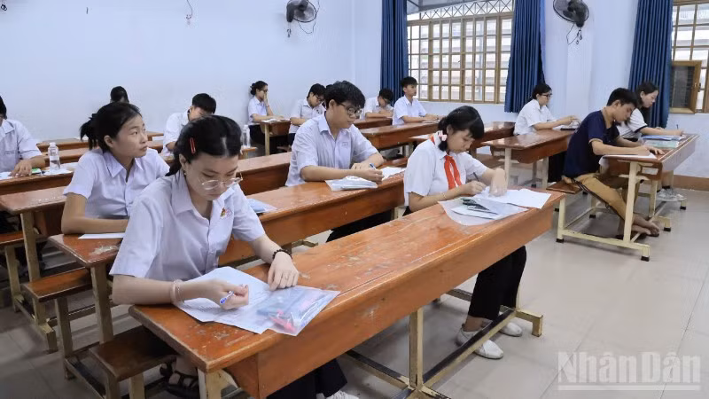 Thí sinh điền thông tin vào giấy thi, chuẩn bị bước vào môn thi đầu tiên tại điểm thi Trường trung học phổ thông Ngô Quyền.