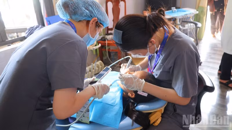 Các y bác sĩ Bệnh viện Răng-Hàm-Mặt thành phố Đà Nẵng khám răng cho học sinh trên địa bàn xã Phước Năng.
