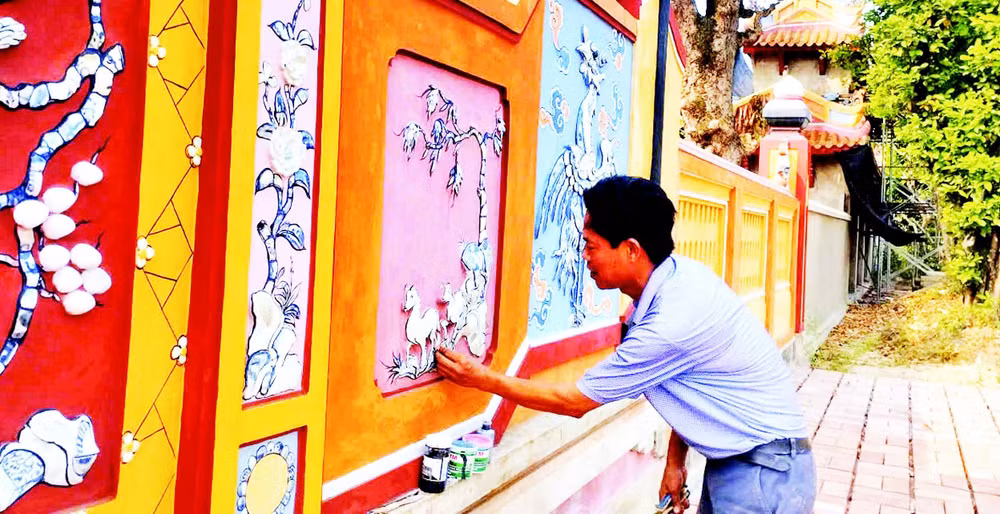 Nghệ nhân Đào Hữu Khiến thực hiện công đoạn khảm sành sứ trên bức bình phong tại Đại nội Huế.