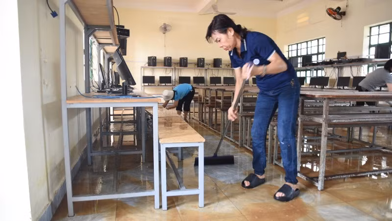Giáo viên Trường trung học cơ sở Phước Tân 1 dọn dẹp phòng học sau lũ.