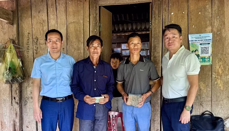 Đồng chí Nguyễn Tiến Thành (đầu tiên bên phải), Chủ tịch Ủy ban nhân dân xã Nậm Kè trao tiền dịch vụ môi trường rừng cho đại diện cộng đồng hai bản. (Ảnh: BÍCH HẠNH)