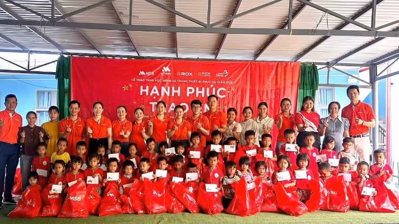 Các em nhỏ nhận quà và học bổng từ chương trình.