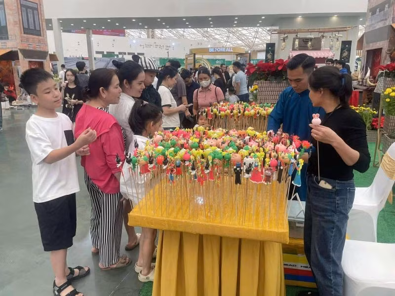 Trẻ em thích thú trải nghiệm gian hàng bán tò he tại Hội chợ Mùa Thu lần thứ nhất - 2025.