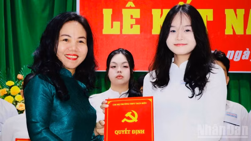 Đồng chí Phạm Thị Thanh Hà, Bí thư Chi bộ, Hiệu trưởng Trường trung học phổ thông Trấn Biên trao quyết định kết nạp đảng viên cho học sinh.