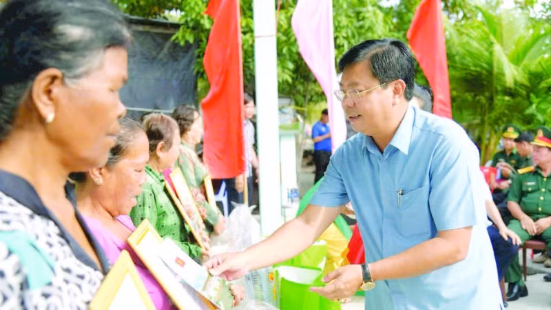 Bí thư Tỉnh ủy An Giang Nguyễn Tiến Hải trao quà tặng người dân tại lễ bàn giao nhà đại đoàn kết trong chương trình “Xóa nhà tạm, nhà dột nát”. (Ảnh QUỐC TRINH)