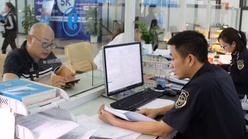 Cán bộ hải quan hướng dẫn, giải quyết thủ tục cho doanh nghiệp tại khu vực làm thủ tục. 