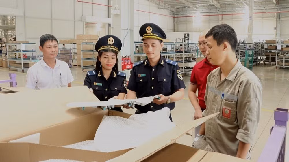 Công chức hải quan kiểm tra Danh mục hàng hóa miễn thuế. (Ảnh: Bùi Nụ)