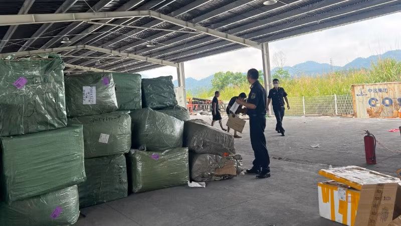 Lực lượng hải quan kiểm tra lô hàng quá cảnh có dấu hiệu vi phạm quyền sở hữu trí tuệ tại khu vực cửa khẩu. (Ảnh: CHQ)
