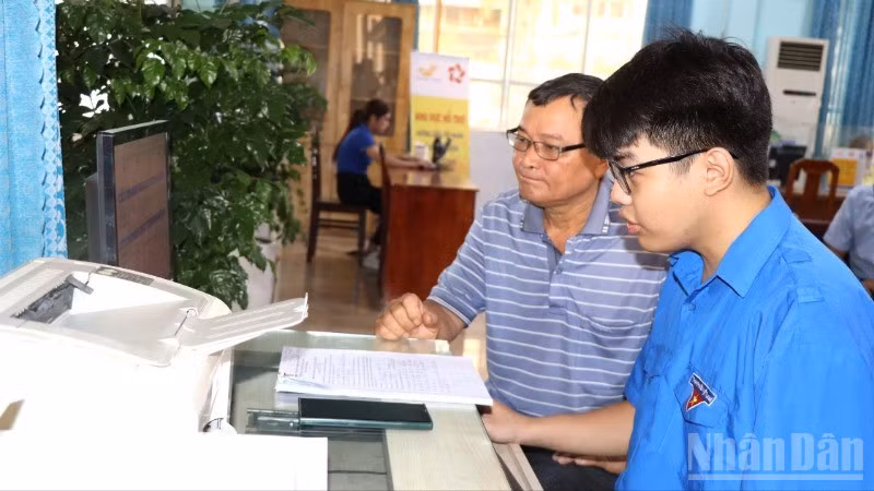Ông Nguyễn Minh Trí được tình nguyện viên Tỉnh đoàn Đồng Nai hỗ trợ nộp hồ sơ trực tuyến.