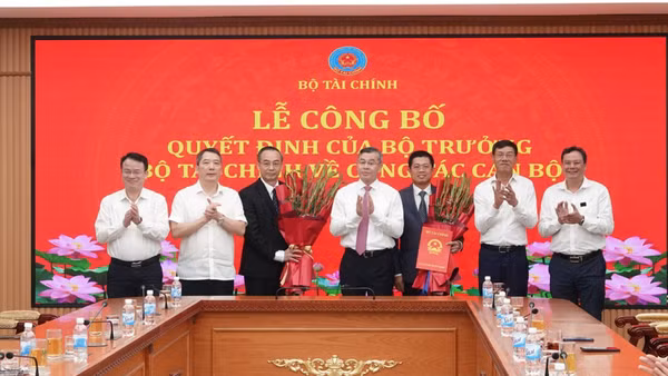 Bộ trưởng Ngô Văn Tuấn trao quyết định, chúc mừng các đồng chí được điều động, bổ nhiệm. (Ảnh: Cổng thông tin điện tử Bộ Tài chính)